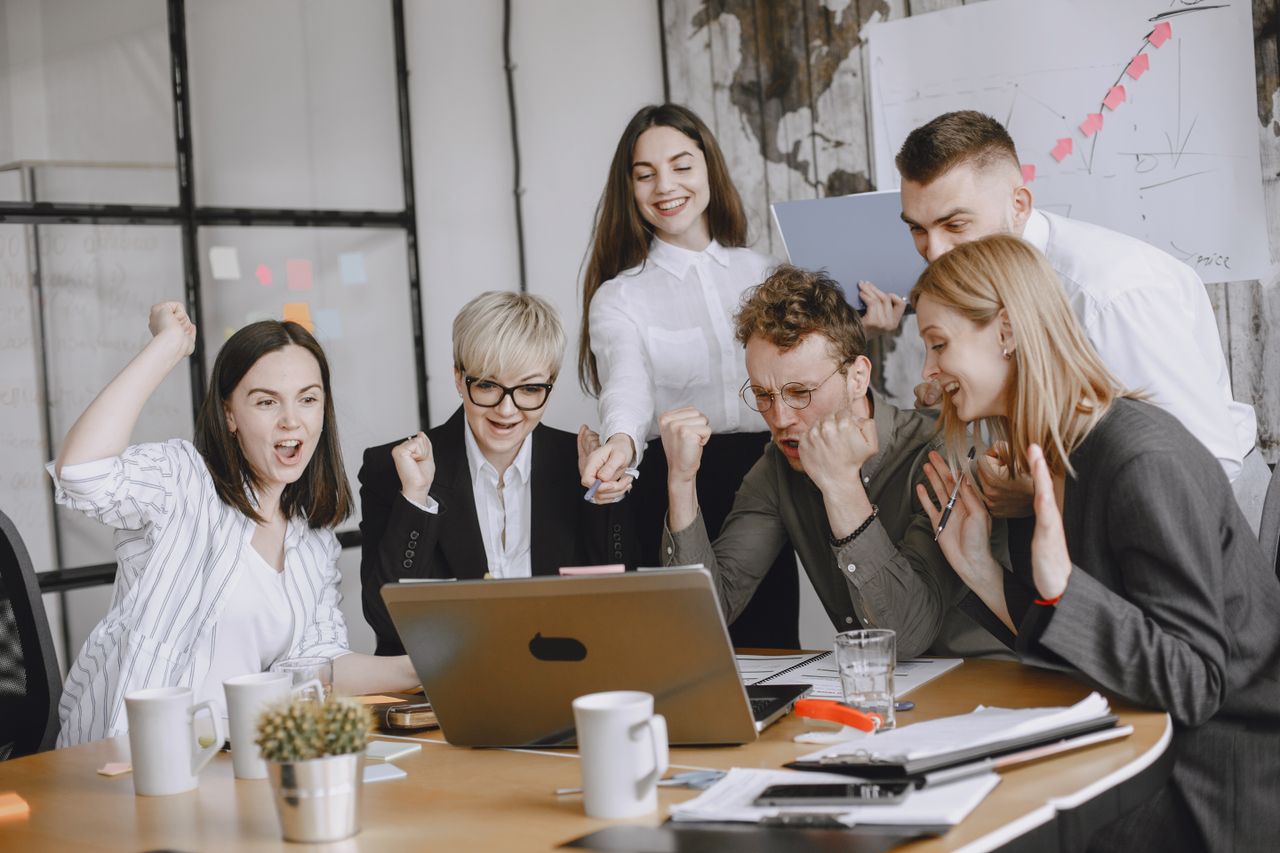Group of diverse colleagues celebrating success in a modern office